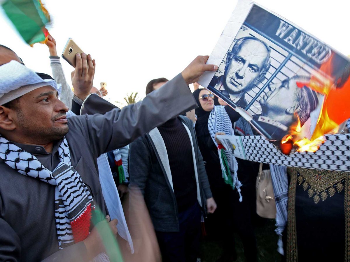 A Kuwaiti demonstrator burns a poster of Israeli Prime Minister Benjamin Netanyahu during a demonstration in front of the National Assembly in Kuwait city on December 9, 2017, following the US president's controversial recognition of Jerusalem as Israel's capital.