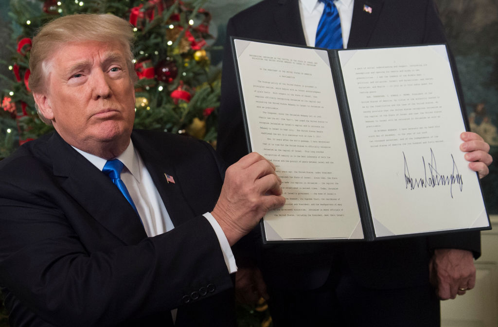 US President Donald Trump holds up a signed memorandum after he delivered a statement on Jerusalem from the Diplomatic Reception Room of the White House in Washington DC on December 6 2017 
Photo: SAUL LOEB/AFP/Getty Images