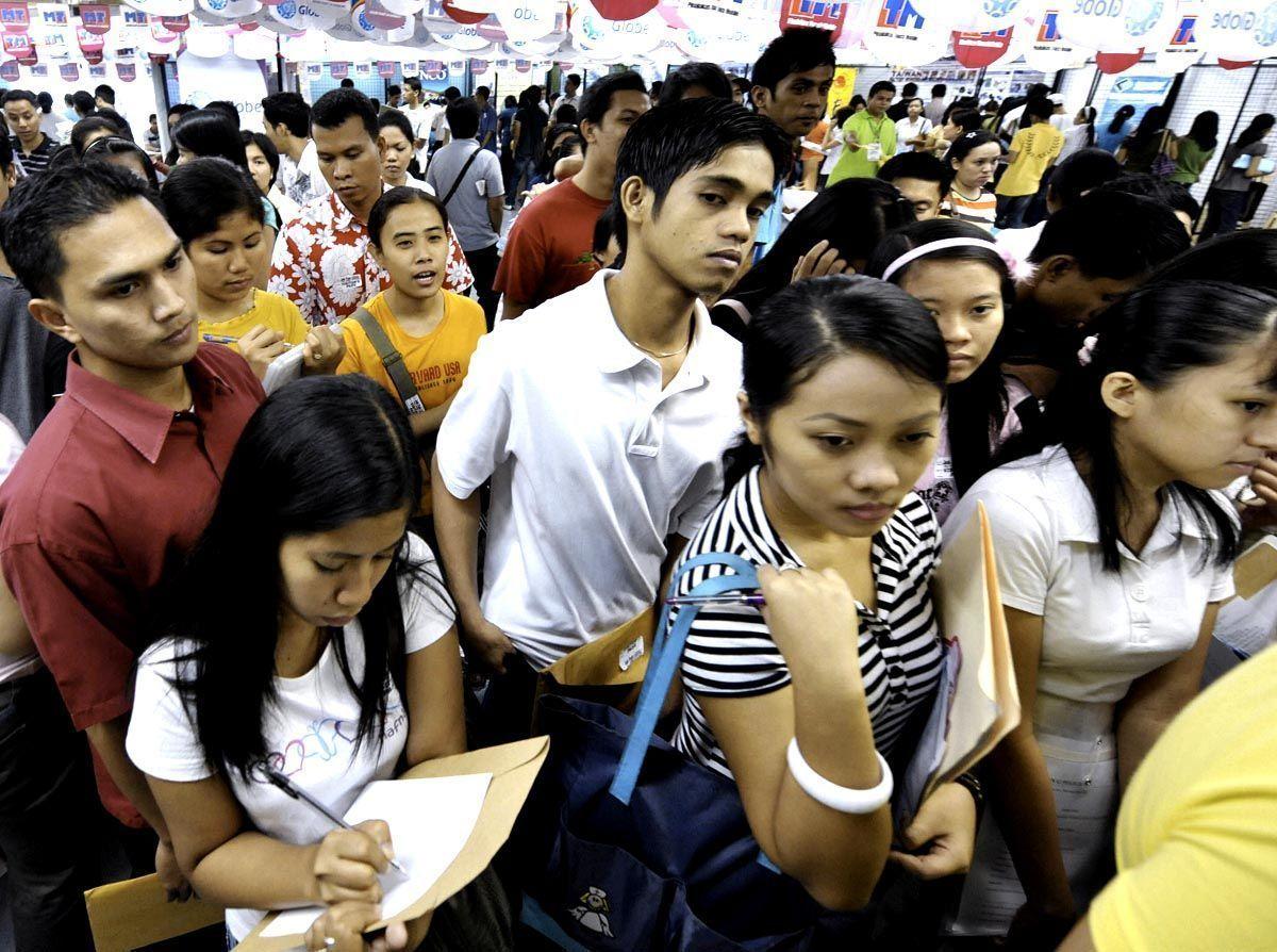 Filipino workers queue for applications at a job fair hiring for overseas roles