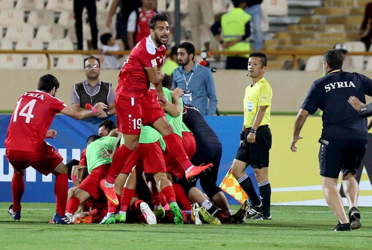 Syria's players celebrate at the end of their FIFA World Cup 2018 qualification football match against Iran at the Azadi Stadium in Tehran on September 5, 2017.