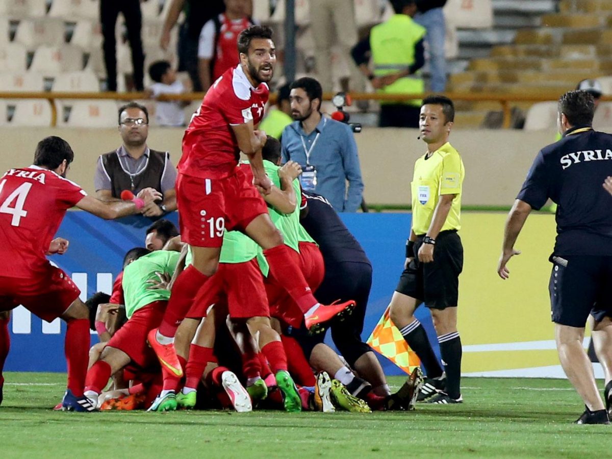 Syria's players celebrate at the end of their FIFA World Cup 2018 qualification football match against Iran at the Azadi Stadium in Tehran on September 5, 2017.