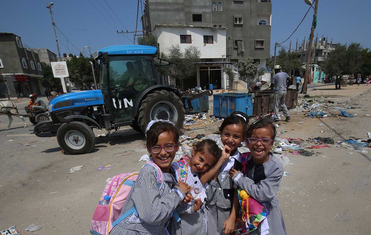 Palestinian school girls pose for a picture near a UN Relief and Works Agency's (UNRWA) tractor in the Rafah refugee camp, southern Gaza Strip. (SAID KHATIB/AFP/Getty Images)