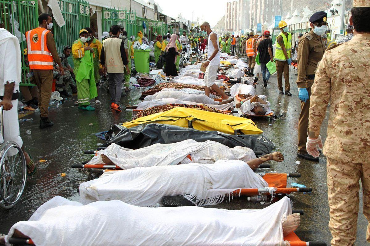 Saudi emergency personnel stand near bodies of Hajj pilgrims at the site where at least 717 were killed and hundreds wounded in a stampede in Mina, near the holy city of Makkah, at the annual hajj in Saudi Arabia on September 24, 2015. The stampede, the second deadly accident to strike the pilgrims this year, broke out during the symbolic