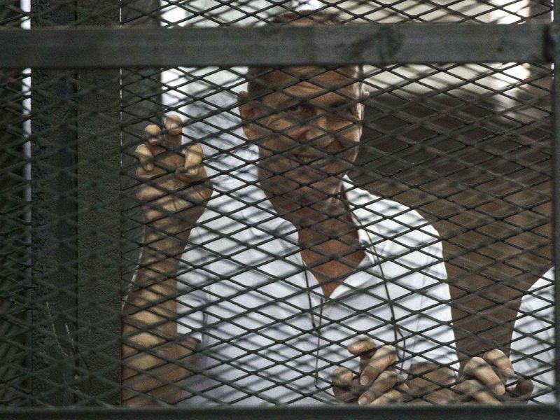 Al-Jazeera channels Australian journalist Peter Greste stands inside the defendants cage during his trial for allegedly supporting the Muslim Brotherhood. (Getty Images)