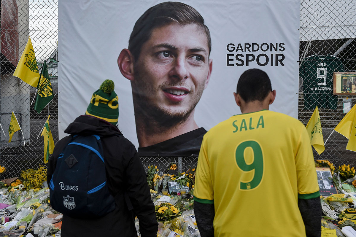 Supporters looks at flowers and messages left in front of a giant portrait of Nantes' Argentinian forward Emilianio Sala before the French L1 football match between FC Nantes and AS Saint Etienne (ASSE) at the La Beaujoire stadium in Nantes, western France on January 30, 2019.