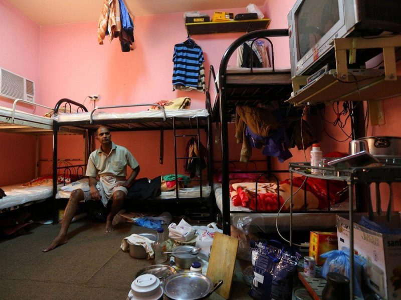 Kupttamon, an Indian labourer working in Qatar, sits in his tiny over-crowded room at a private camp housing foreign workers in Doha. (AFP/Getty Images)