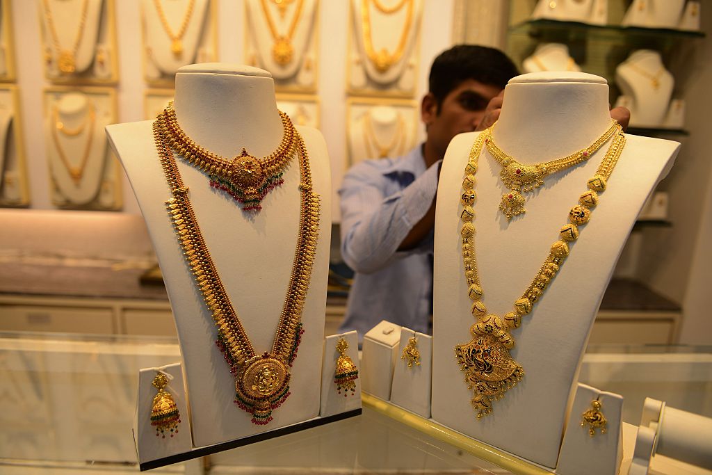 An Indian salesperson adjusts gold items for sale at a jewellers in Hyderabad 
Photo: NOAH SEELAM/AFP/Getty Images.