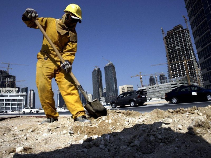 TO GO WITH AFP STORY BY FAISAL BAATOUT: A construction worker digs at a building site while in the background numerous cranes are positioned around high-rise ?apartment buildings under development in the Qatari capital Doha, 01 October 2007. Qatar ?is enjoying dramatic economic growth on the back of surging gas revenues, but the Gulf ?stat