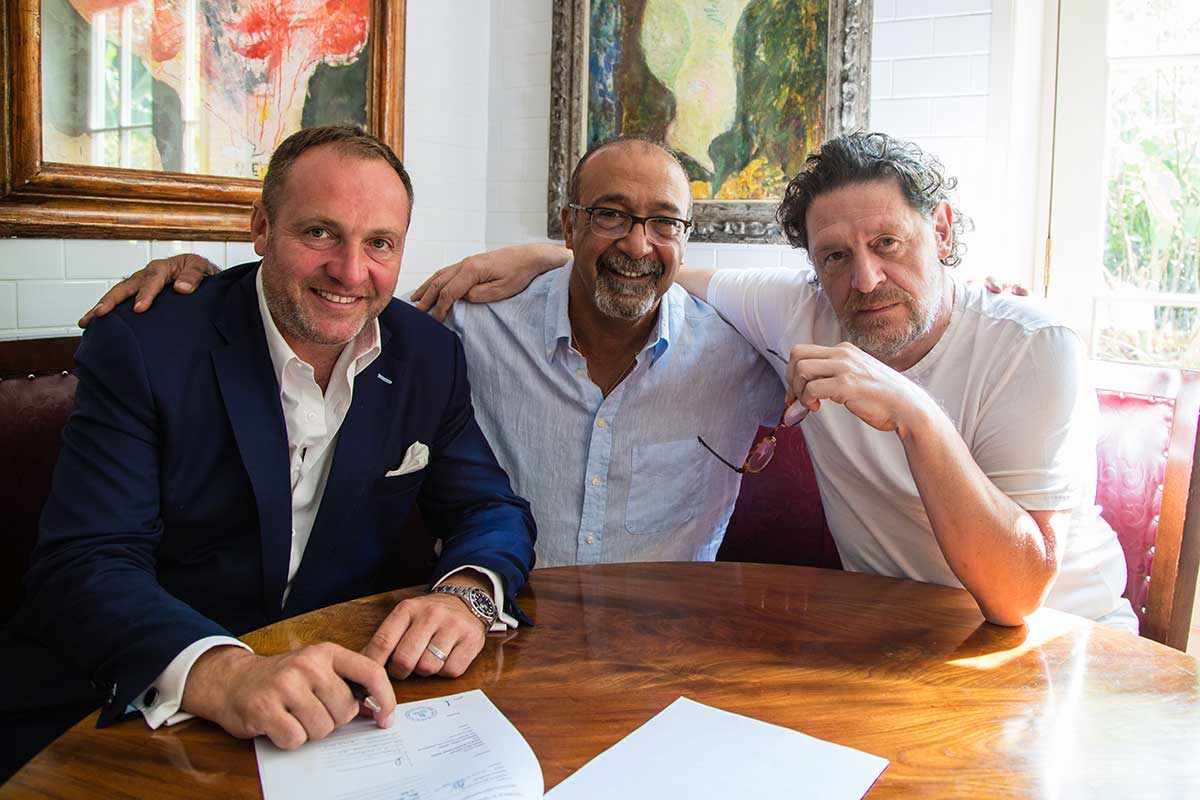 Nick Taplin, chairman and CEO of Black and White Hospitality, Jihad Hazzan, chief operating officer of Al Fahim Hospitality and Marco Pierre White pictured signing the agreement to form Black and White International.