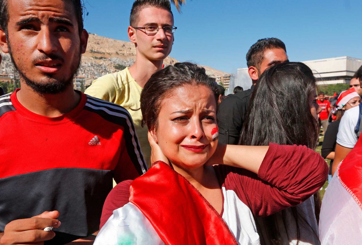 Syrians react after their national team lost to Australia in the World Cup qualifying play-off football match as they gathered at the Umayyad Square in Damascus on October 10, 2017, where the match was being broadcast. After last week's 1-1 draw in Malaysia, Australia won 3-2 on aggregate to reach a final play-off against the fourth-placed