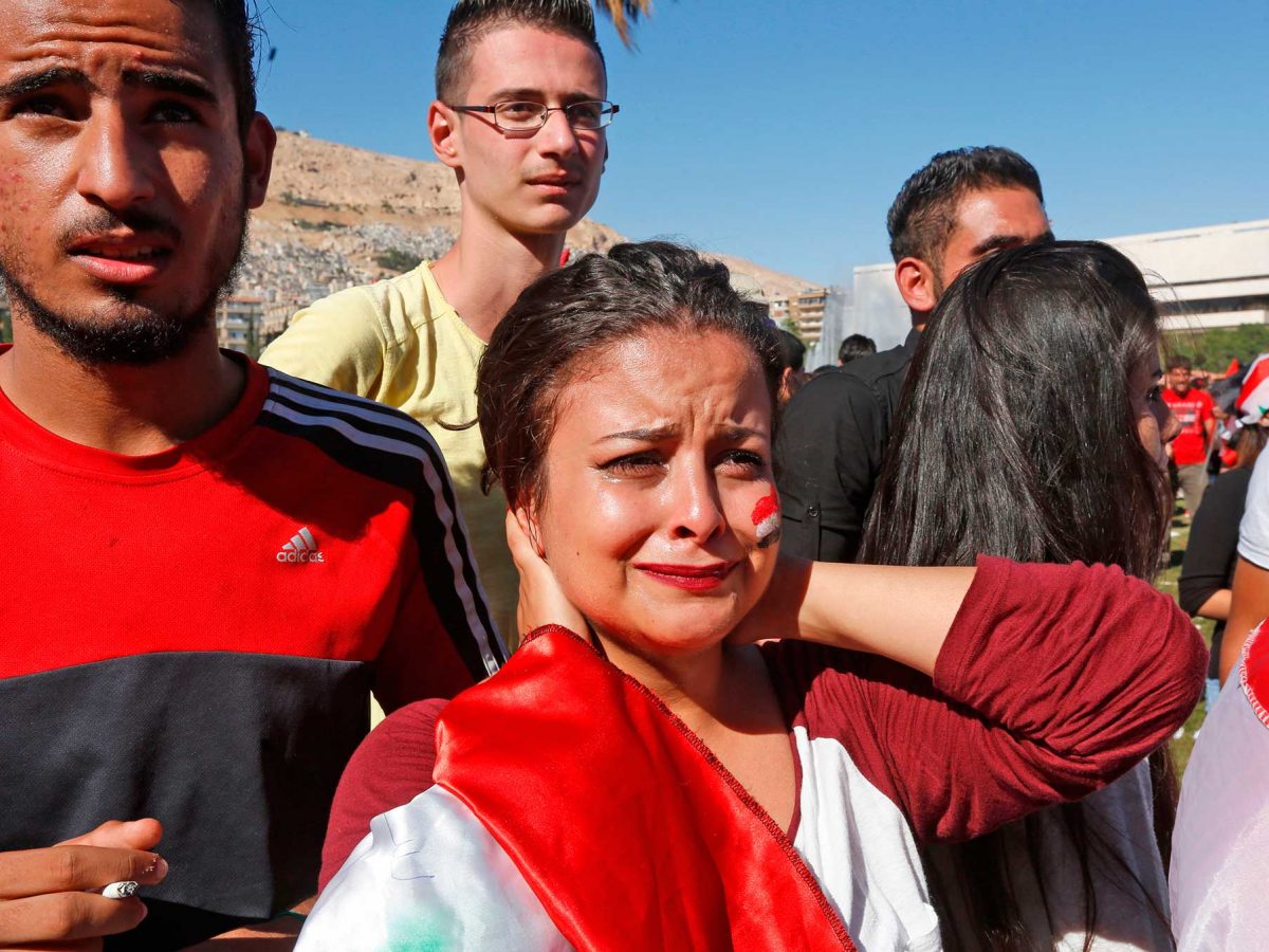 Syrians react after their national team lost to Australia in the World Cup qualifying play-off football match as they gathered at the Umayyad Square in Damascus on October 10, 2017, where the match was being broadcast. After last week's 1-1 draw in Malaysia, Australia won 3-2 on aggregate to reach a final play-off against the fourth-placed