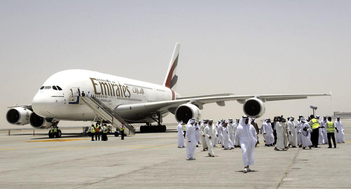 Members of the media and officials walk on the runway in front of an Emirates Airlines plane during the media tour of Dubais new second airport, Dubai World Central or Al-Maktoum International.