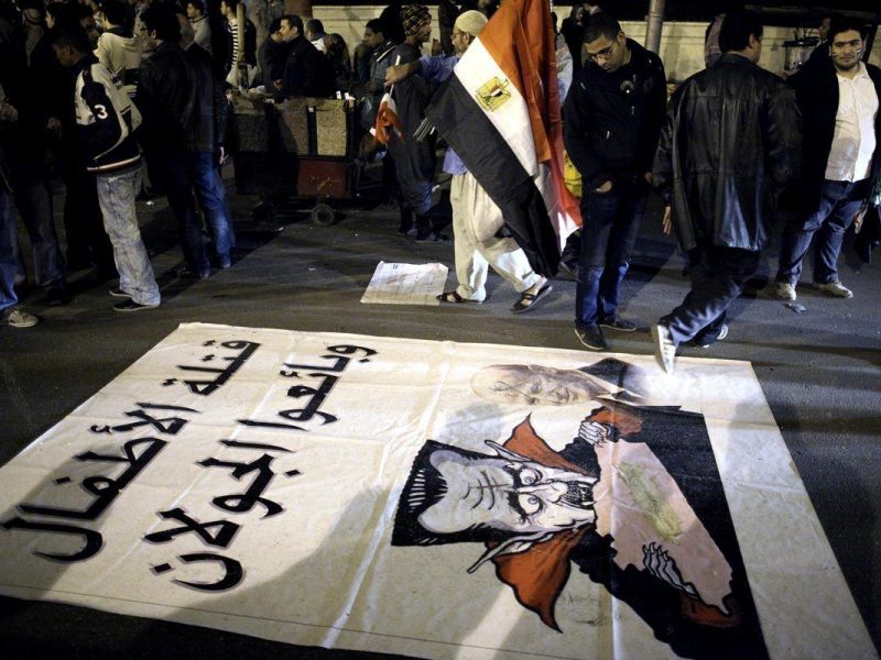 A caricature of Syrian President Bashar al-Assad is spread on the ground as Syrian people demonstrate outside the Arab League building in Cairo Egypt. (Getty Images)