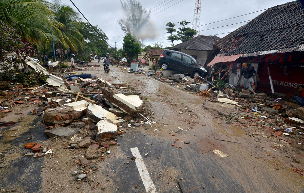 Residents inspect damaged buildings in Carita on December 23, 2018, after the area was hit by a tsunami on December 22 following an eruption of the Anak Krakatoa volcano.