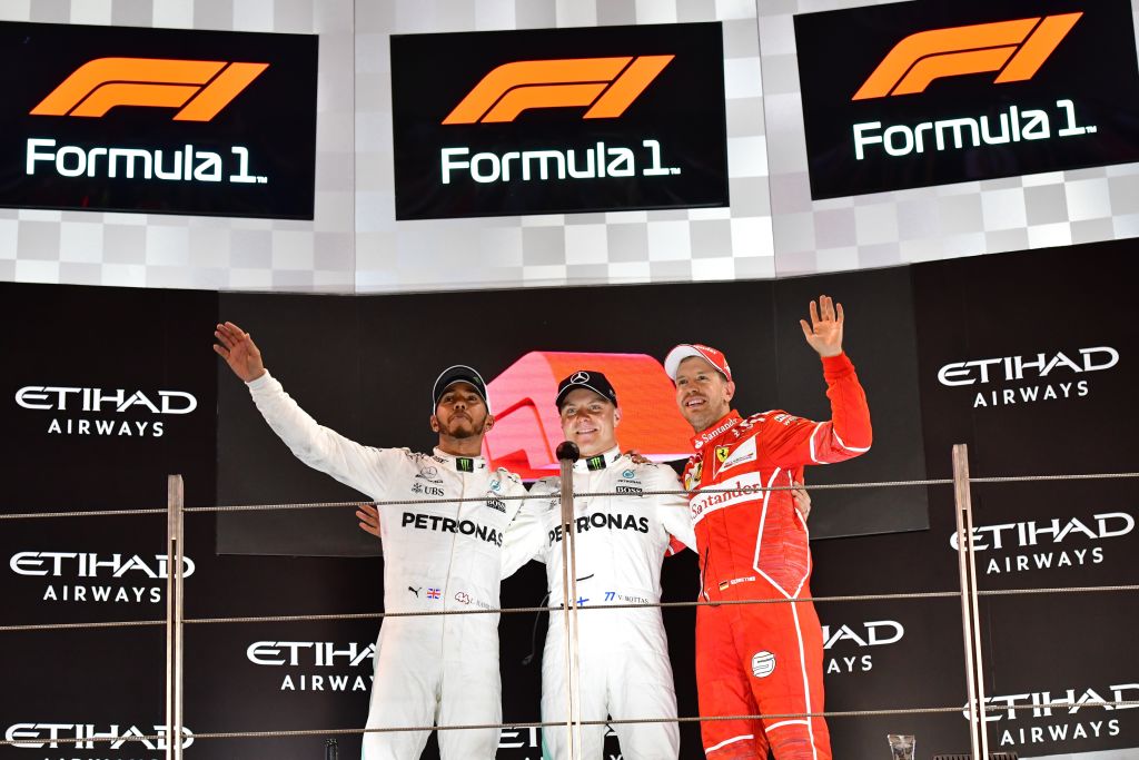 Mercedes British driver Lewis Hamilton, Mercedes Finnish driver Valtteri Bottas and Ferrari's German driver Sebastian Vettel celebrate on the podium at the end of the Abu Dhabi Formula One Grand Prix at the Yas Marina circuit 
Photo: GIUSEPPE CACACE/AFP/Getty Images.