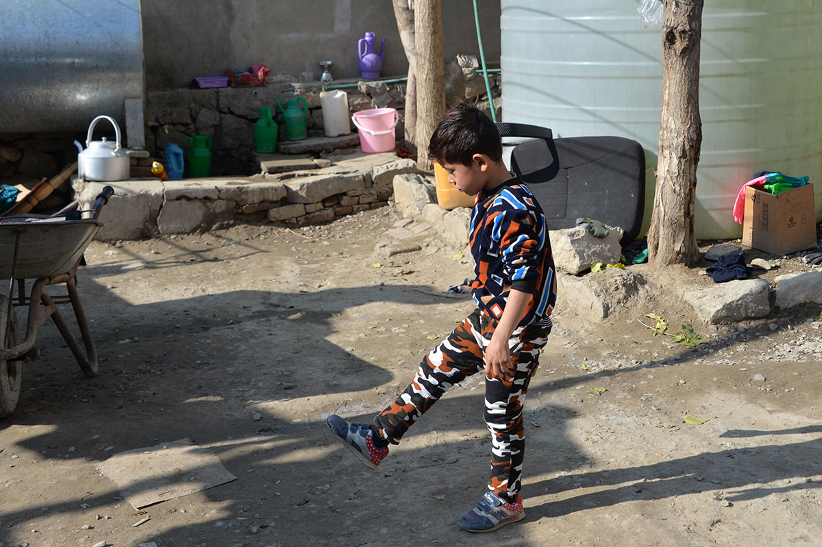 Murtaza Ahmadi, a supporter of Argentine footballer Lionel Messi, kicking stones outside his home in Kabul.