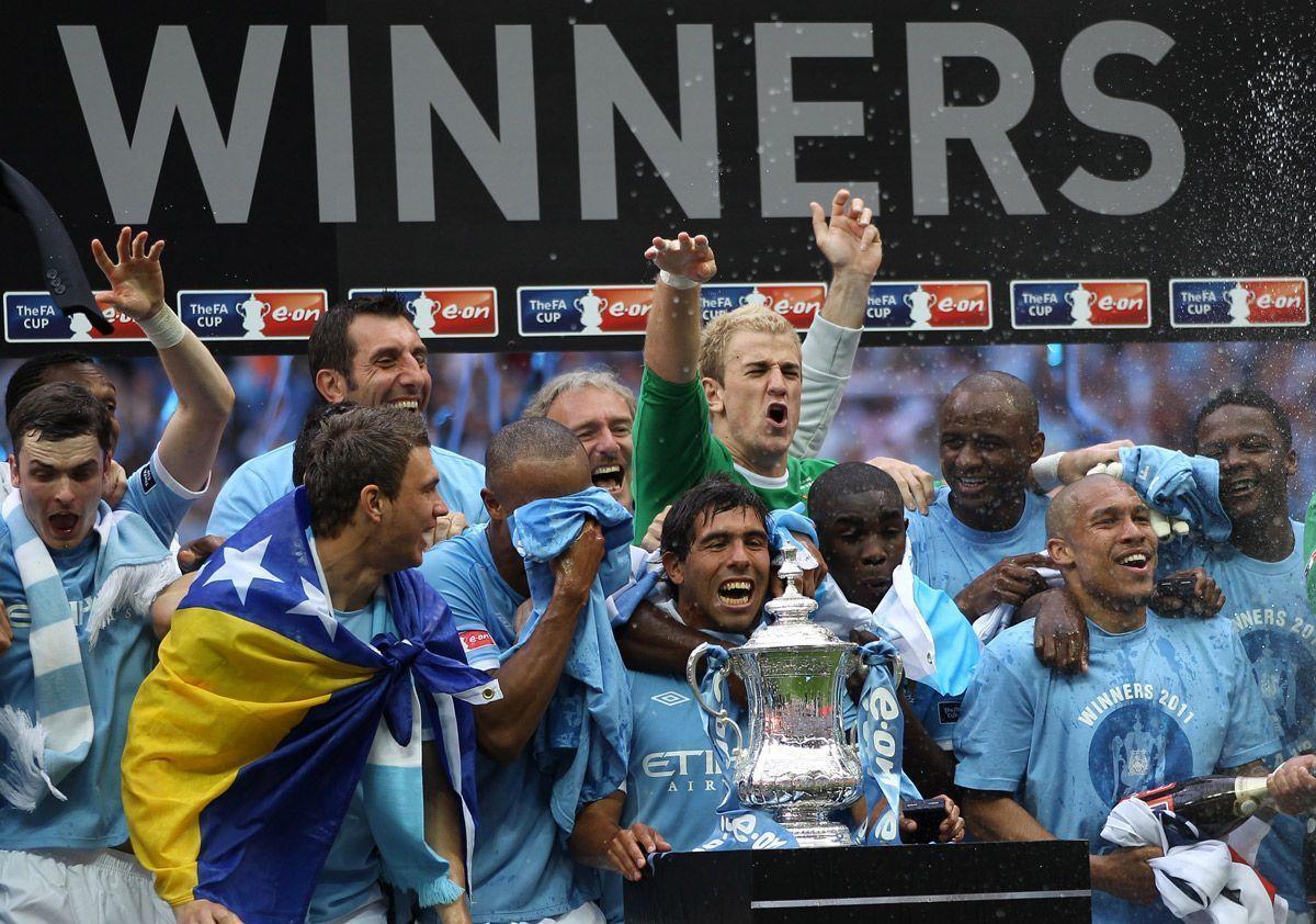 Manchester Citys Argentinian footballer Carlos Tevez (C) celebrates with the FA Cup. (AFP/Getty Images)