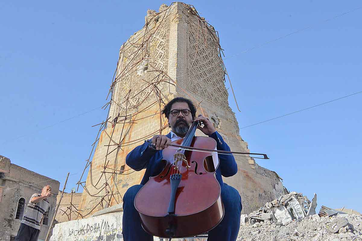 Famed Iraqi maestro and cello player Karim Wasfi performs in front of the Great Mosque of al-Nuri in Mosuls war-ravaged Old City on June 29, 2018, one year after the mosque was destroyed during battles to retake the city from the ISIL group.