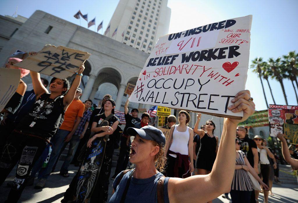 Protesters hold signs after a march to Los Angeles City Hall during the Occupy Los Angeles demonstration in solidarity with the ongoing Occupy Wall Street protest in New York City on October 1, 2011 in Los Angeles, California. (Getty Images)