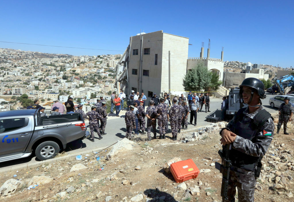 Jordanian security forces gather near a damaged building in the city of Salt northwest of the capital Amman .
Photo: KHALIL MAZRAAWI/AFP/Getty Images.