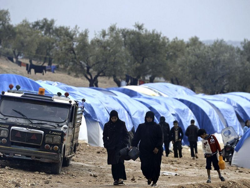 Syrians walk by tents on a refugee camp in Qah, near the northwestern Syria city of Idlib on November 24, 2012. (AFP/Getty Images)