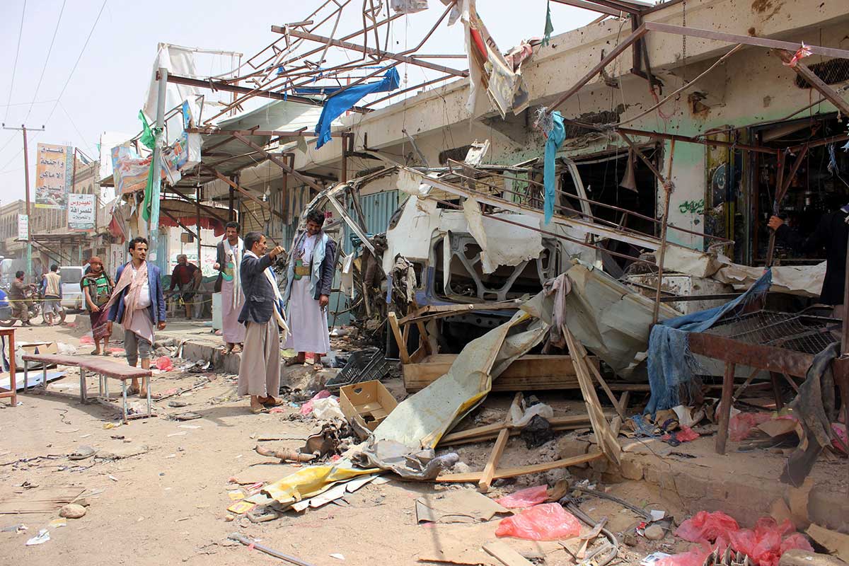 Yemenis gather next to the destroyed bus at the site of a Saudi-led coalition air strike, that targeted the Dahyan market the previous day in the Huthi rebels' stronghold province of Saada on August 10, 2018.