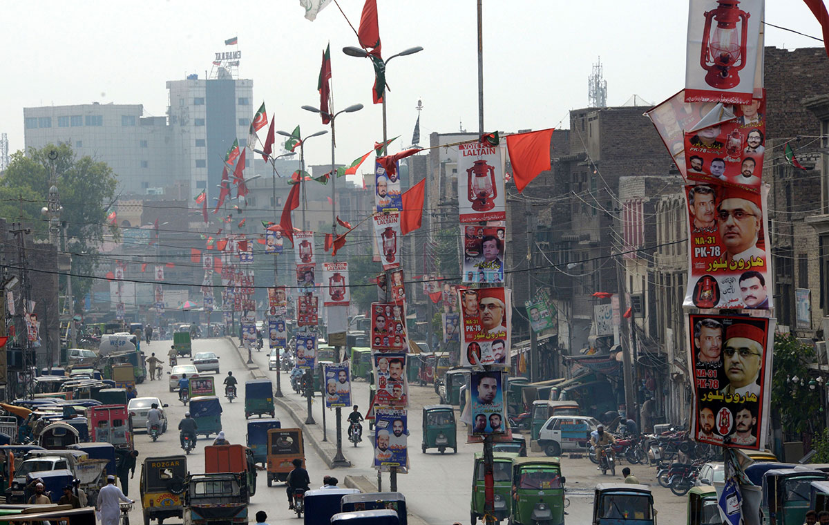 Pakistani commuters drive past election posters displayed on a street in Peshawar. Pakistan goes to the polls on July 25 for tense nationwide elections marked by deadly attacks and accusations of military interference that could undermine their legitimacy.