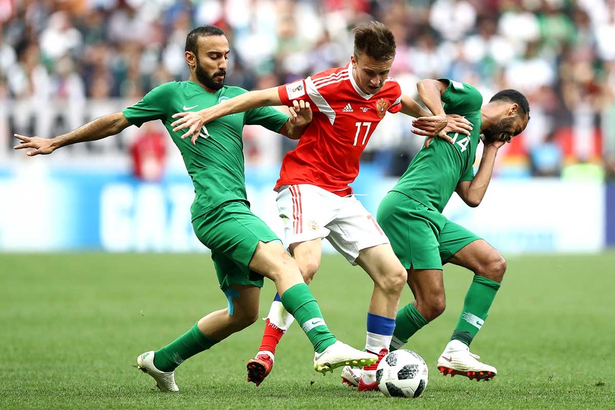 Fedor Smolov of Russia controls the ball under pressure of Mohammed Alsahlawi and Abdullah Otayf of Saudi Arabia during the 2018 FIFA World Cup Russia Group A match between Russia and Saudi Arabia at Luzhniki Stadium on June 14, 2018 in Moscow, Russia.