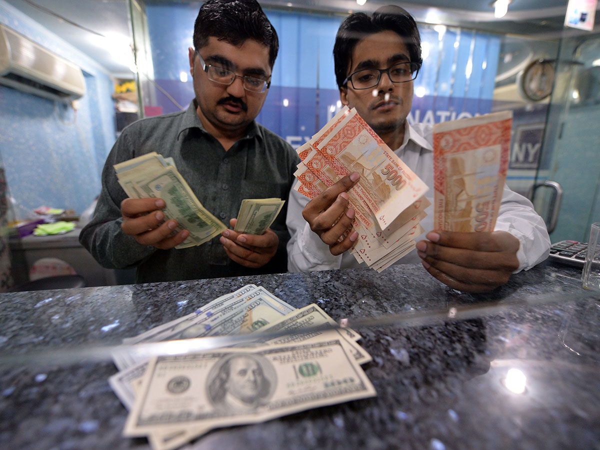 Money dealers counts Pakistani rupees and US dollars at a currency exchange in Islamabad. (AAMIR QURESHI/AFP/Getty Images - for illustrative purposes only)