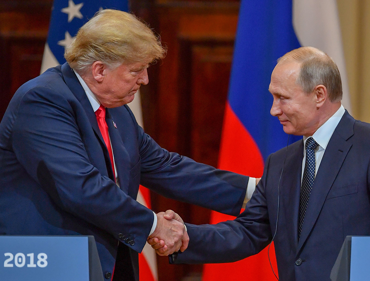 US President Donald Trump (L) and Russia's President Vladimir Putin shake hands before attending a joint press conference after a meeting at the Presidential Palace in Helsinki, on July 16, 2018.