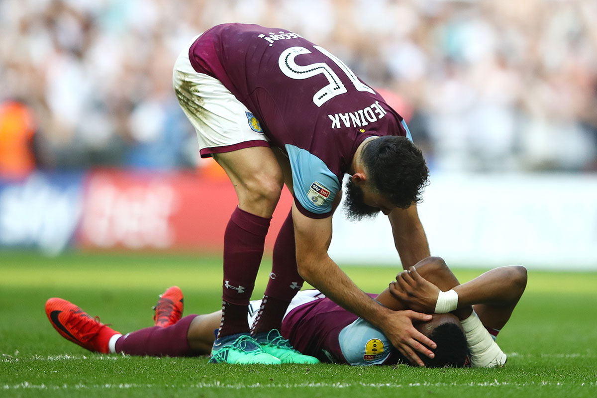 Mile Jedinak of Aston Villa consoles Jonathan Kodija of Aston Villa following their sides defeat in the Sky Bet Championship Play Off Final between Aston Villa and Fulham at Wembley Stadium on May 26, 2018 in London, England.