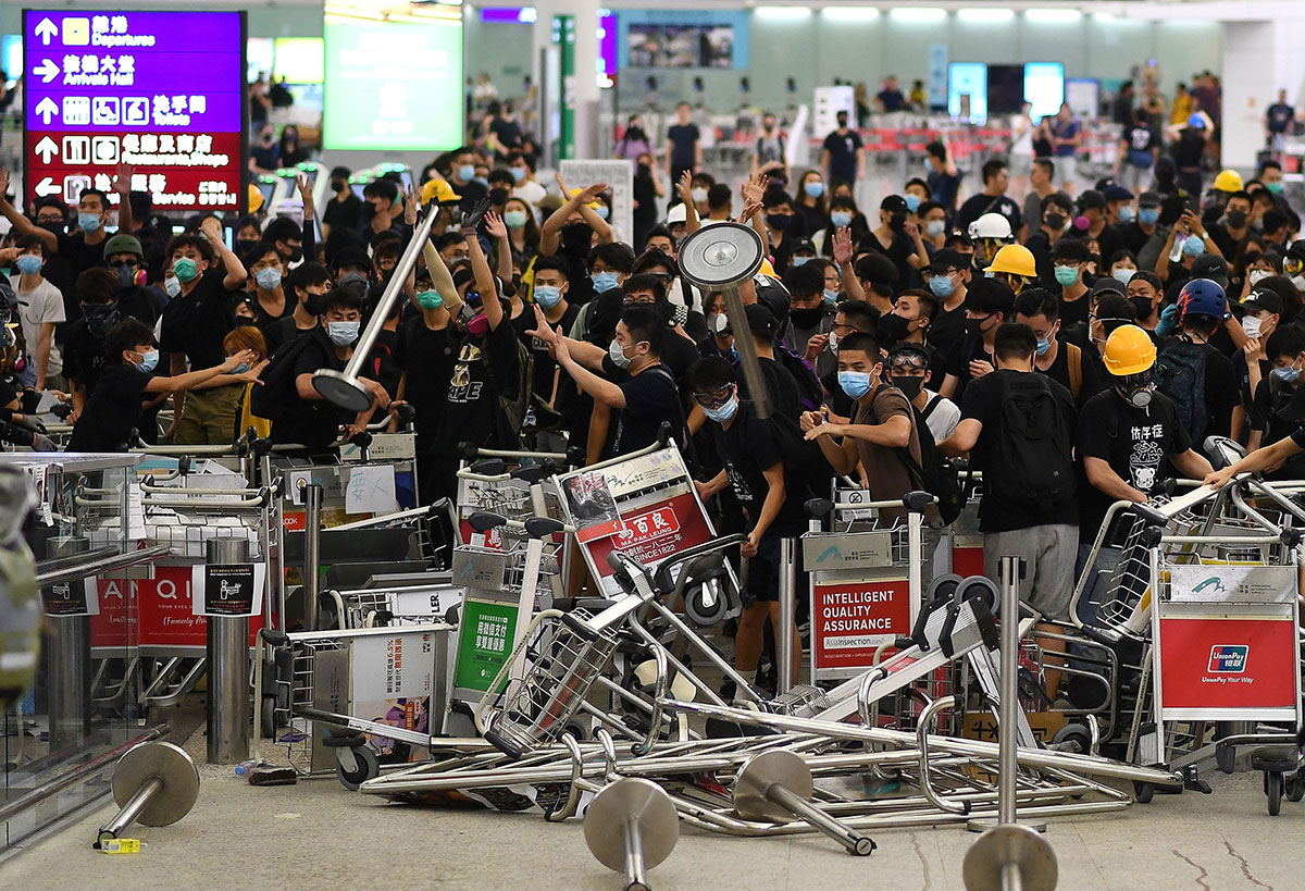 Pro-democracy protestors block the entrance to the airport terminals after a scuffle with police at Hong Kong International Airport late on August 13, 2019.