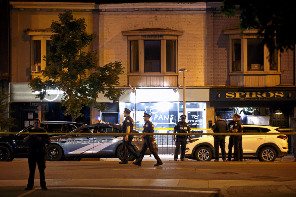 Toronto Police officers walk the scene at Danforth St at the scene of a shooting in Toronto 
Photo: COLE BURSTON/AFP/Getty Images