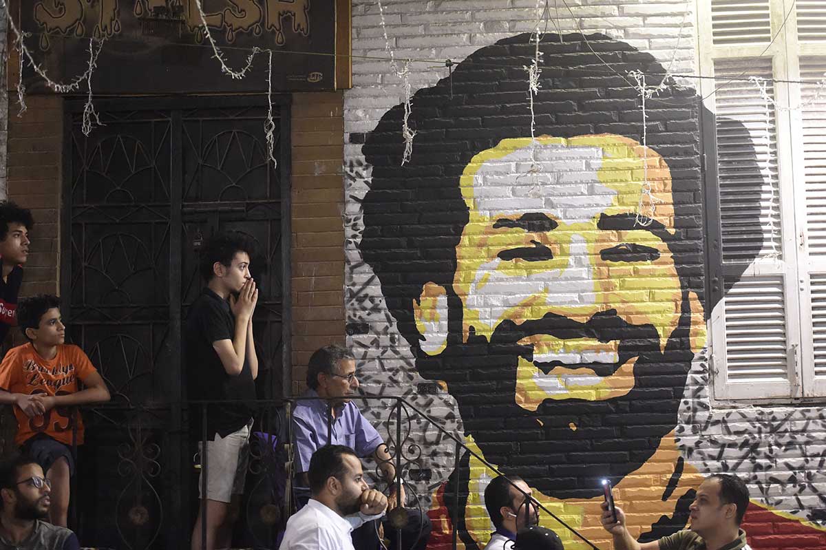 People watch the the UEFA Champions League final football match, between Real Madrid and Liverpool, at a coffee shop in the Egyptian capital Cairo. On the wall is a painting of Liverpool Egytian forward Mohamed Salah. Liverpool suffered the loss of 44-goal top scorer Mohamed Salah to a shoulder injury on 31 minutes, after a tangle with Rea