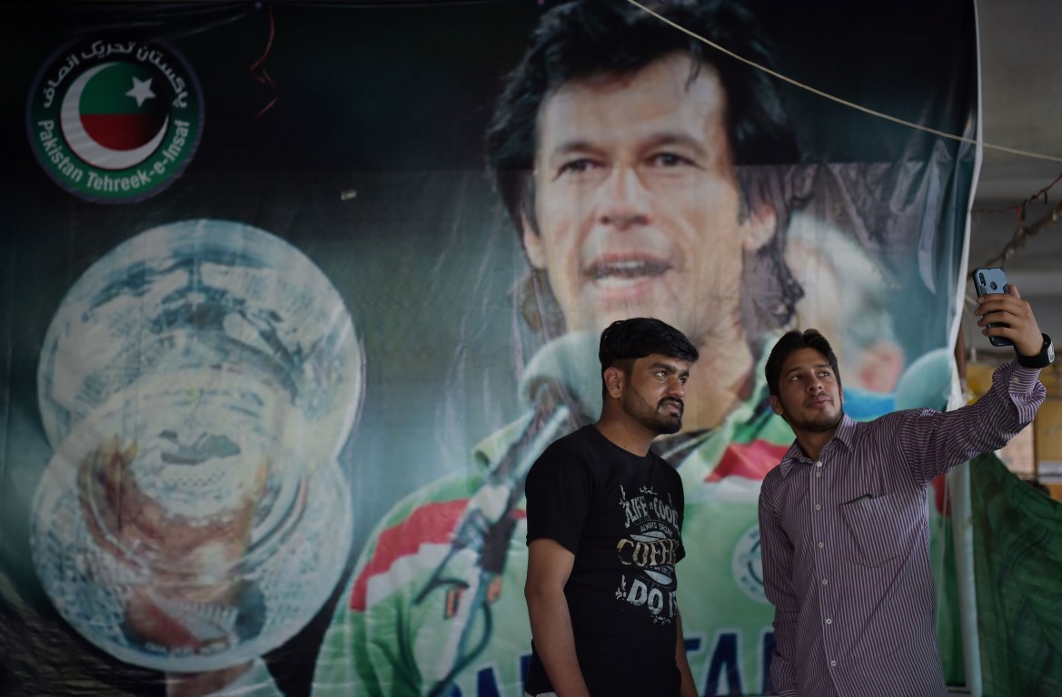 Pakistani youths take a selfie with a poster of World Cup cricket hero turned PM Imran Khan in Islamabad. (AAMIR QURESHI/AFP/Getty Images)