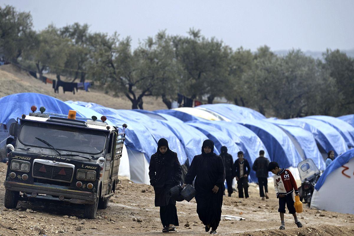 Syrians walk by tents on a refugee camp in Qah, near the northwestern Syria city of Idlib on November 24, 2012. (AFP/Getty Images)