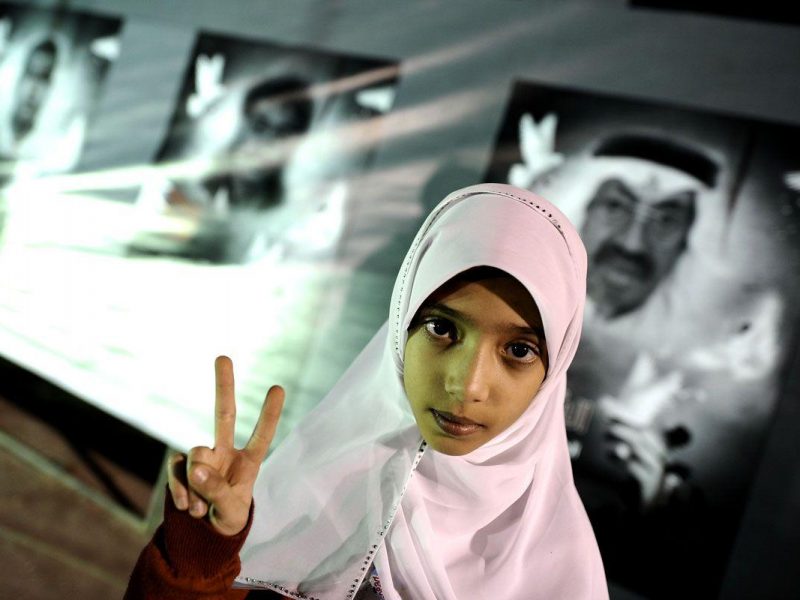 A Bahraini Shiite girl flashes a victory sign during an anti-government rally