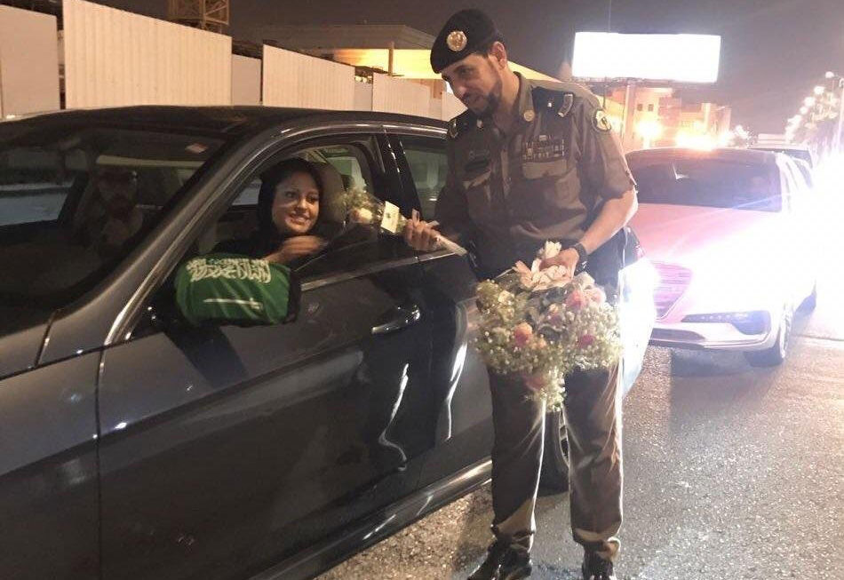 Warm welcome police hand out flowers to a passing female driver