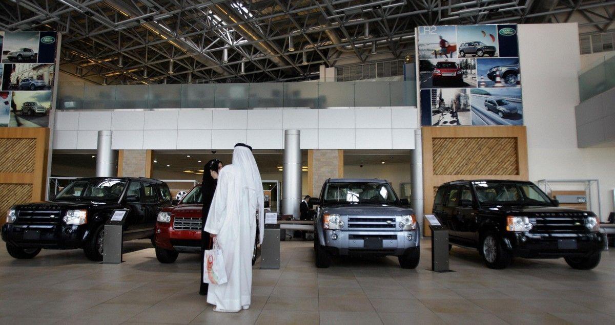 Visitors look at luxury cars displayed at a showroom in Dubai. (Getty Images)