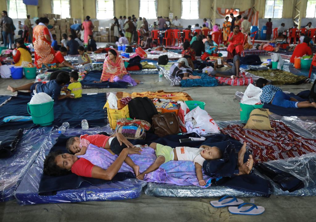 An Indian woman rescued by the Indian navy personnel rests with her grandchildren at the Naval relief camp in Kochi in the Indian state of Kerala. Photo: AFP/Getty Images.