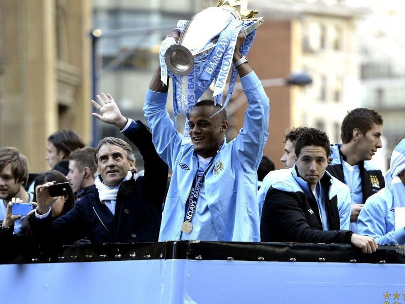 Vincent Kompany parades the Barclays Premier League trophy in front of thousands of fans during their victory parade around the streets of Manchester on May 14. (Getty Images)