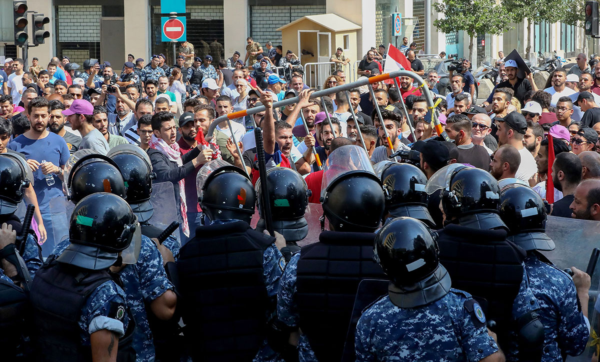 Lebanese protesters clash with riot policemen as they try to break through security barriers in front of the cabinet office during a demonstration in central Beirut's Martyr Square.