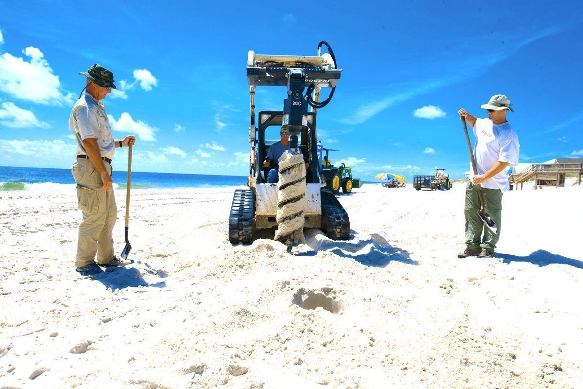 Beach clean-up teams on the Gulf of Mexico coastline. Sand core analysis tests for oil presence beneath the surface.