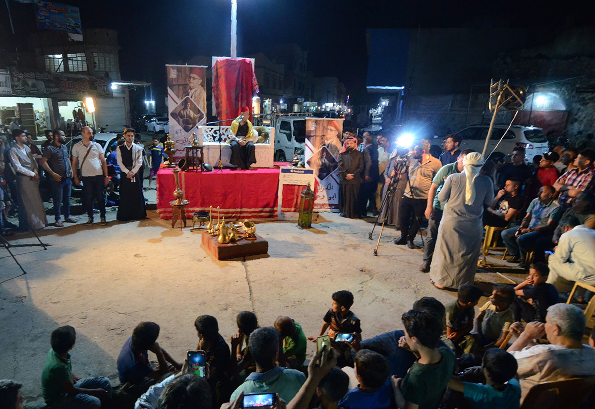 Traditional storyteller Abdel Wahed Ismail (on stage), entertains an audience in the northern Iraqi city of Mosul, during the holy Muslim month of Ramadan.