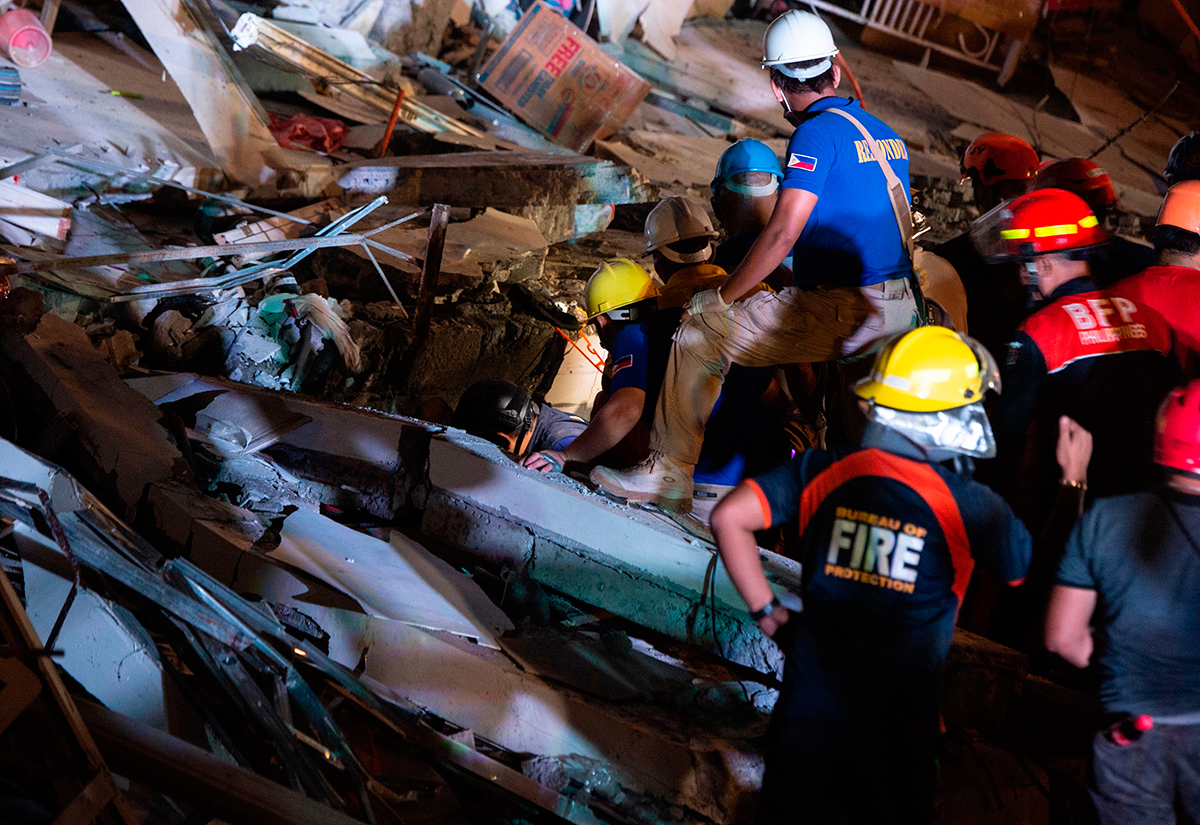 Rescue workers search for survivors in a collapsed Chuzon Super Market in Porac, Pampanga, after a powerful earthquake hit northern Philippines on April 22, 2019.