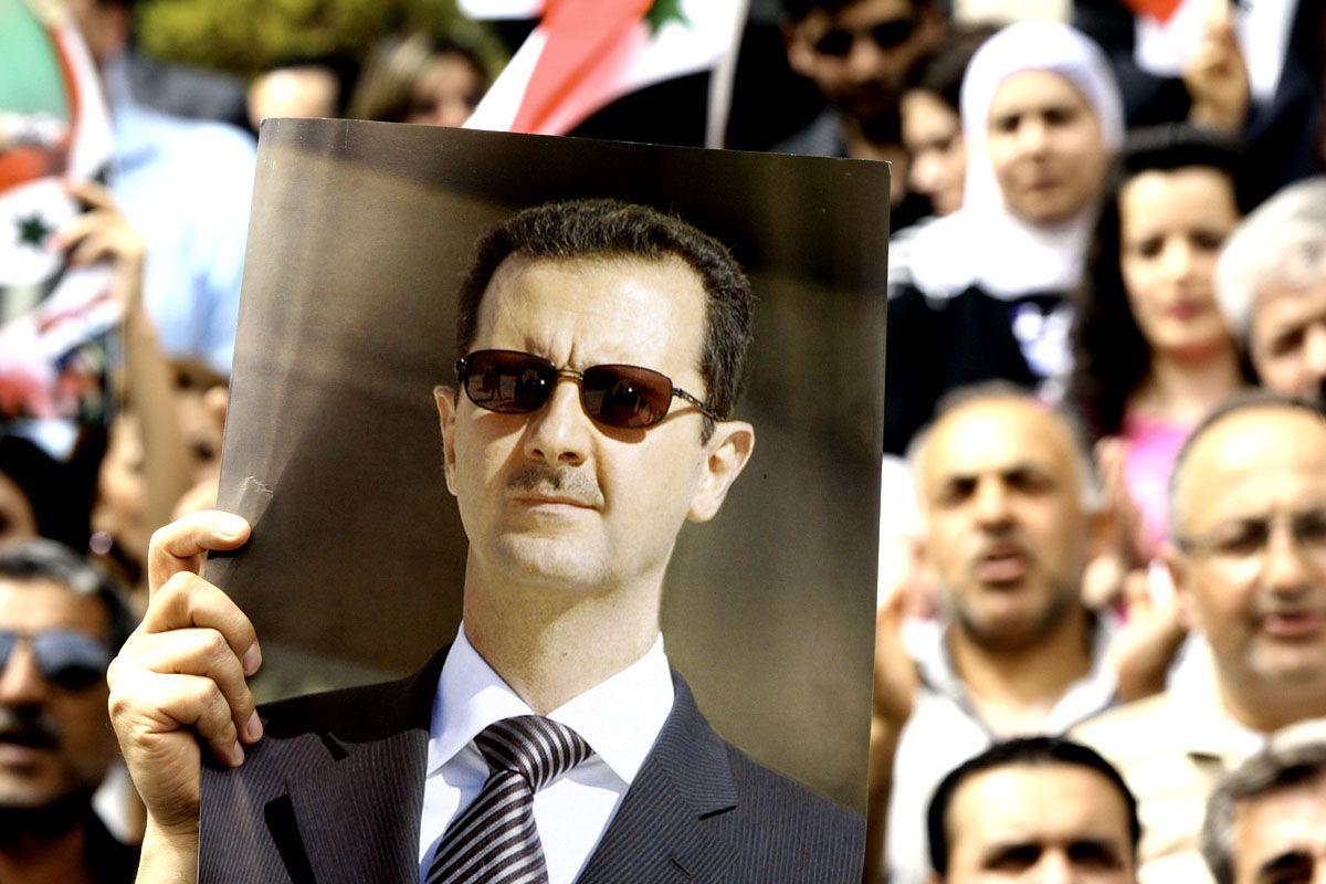 Syrian protestors hold up a picture of President Bashar al Assad during a demonstration in Damascus. (LOUAI BESHARA/AFP/GettyImages - for illustrative purposes only)